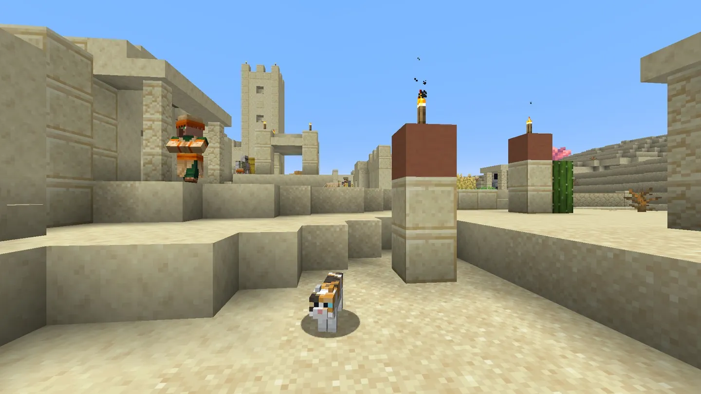 Sandstone houses, villagers and a cat viewed from the recorded first player spawn in a desert village. In-game screenshot, Java 26.3.