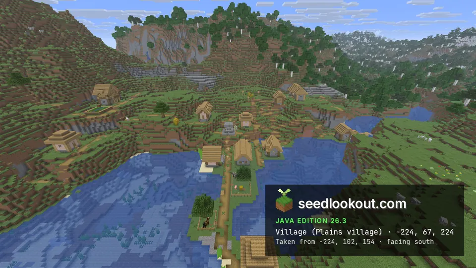 Wooden village around a blue pond in a valley, steep wooded hills behind
