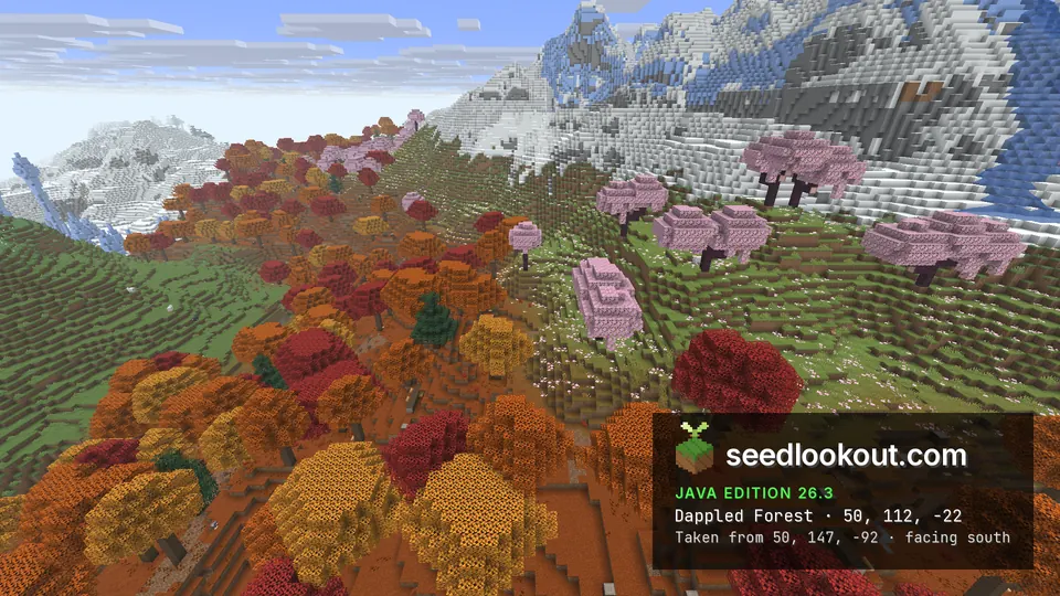 Red, orange and pink trees on a meadow slope, a snowy rocky ridge with patches of blue ice rising behind