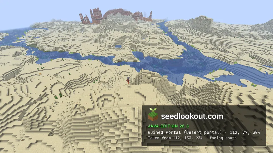 Sand dunes and a winding river, with red rock spires on the far horizon