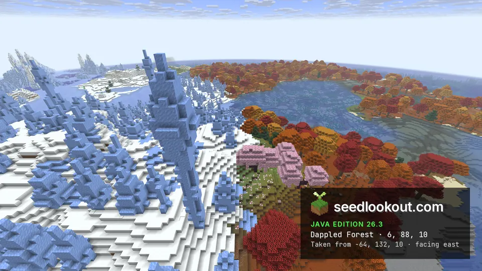 Tall blue ice spikes beside a lake shore of red, orange and pink trees, more dappled forest across the water