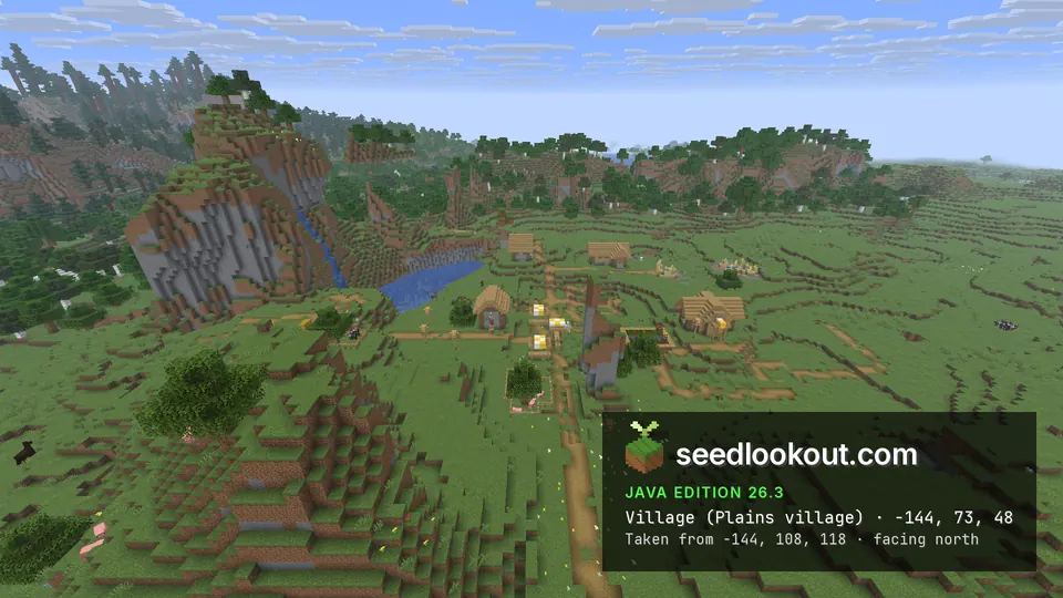 Wooden village on grassy ground beside a tall rock outcrop with a waterfall and a pool